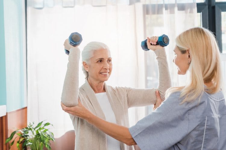 physical therapist showing stroke patient arm exercises to help regain movement