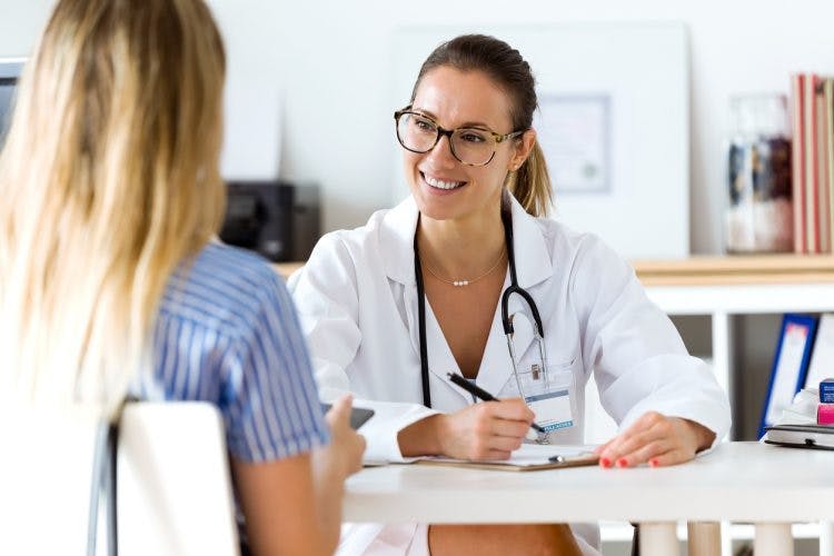 Doctor writing prescription for patient