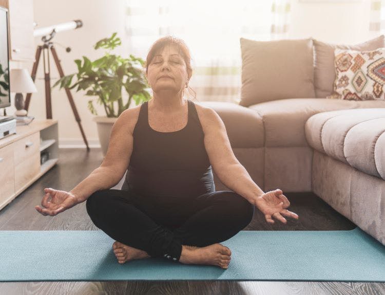 senior stroke survivor doing meditation on a yoga mat to practice mindfulness
