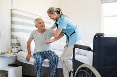 man getting help out of bed after a left hemisphere stroke