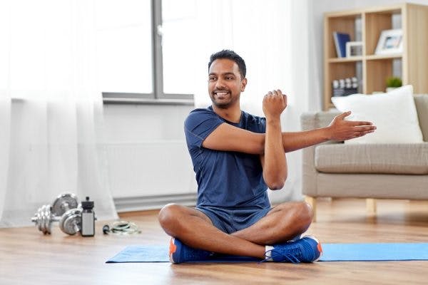 年代urvivor sitting down on a mat practicing hand exercises for spinal cord injury