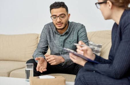 man talking with therapist during psychotherapy session to help him understand and overcome the effects of brain injury and mental health issues 