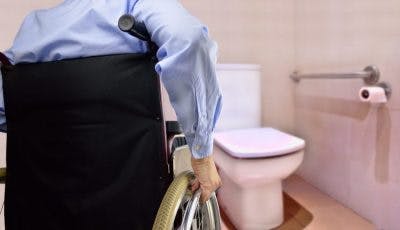 man in wheelchair after spinal cord injury transferring onto toilet