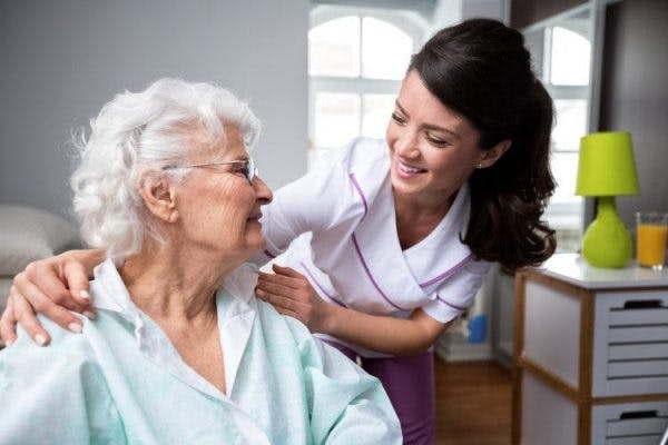 nurse helping elderly woman with spinal cord injury initiate bowel program