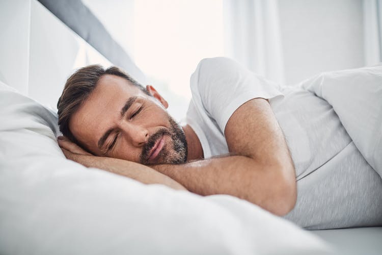 middle aged man sleeping after head injury with hands under head