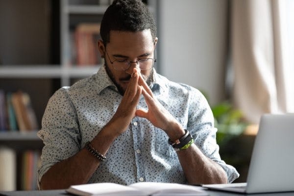 man sitting at desk looking stressed from PTSD after brain injury