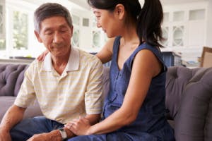 Adult daughter comforting father who has suffered a brain injury