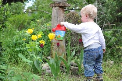 child with cerebral palsy watering flower to practice wrist control