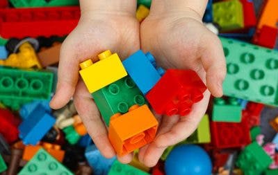 kid with cerebral palsy playing with legos to develop strength in fingers