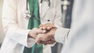 Close up of doctor holding patient's hand