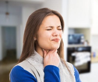 Woman grasping throat and struggling to swallow because she has dysphagia after head injury