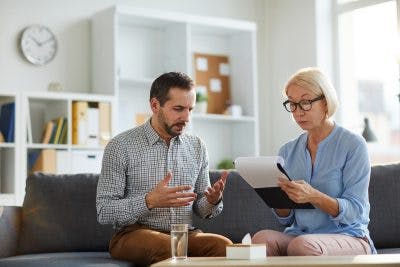 Man describing problem to therapist during cognitive behavioral therapy session for traumatic brain injury