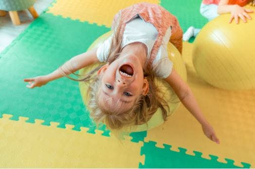 child practicing cp balancing exercise with stability ball