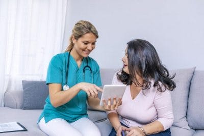 physical therapist showing patient how to do her exercises at home