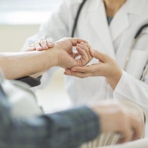 therapist helping patient with grasp and release activities stroke