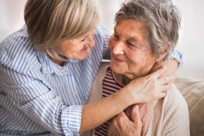 daughter comforting elderly mother