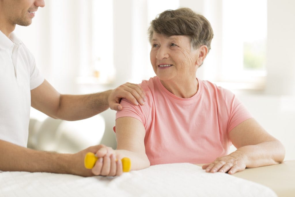 elderly woman exercising with therapist to regain arm movement