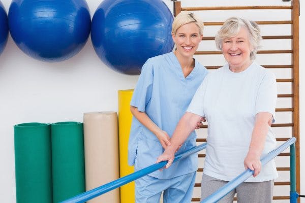 stroke patient and therapist doing gait rehabilitation with parallel bars to improve walking after stroke