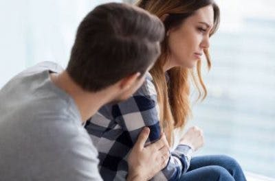 Boyfriend consoling girlfriend experiencing depression, which may cause cognitive effects of spinal cord injury