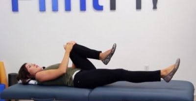 physical therapist lying down showing stroke rehab exercises for core