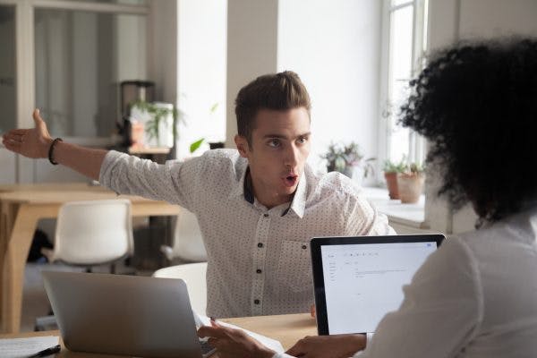 angry man yelling at coworker because he struggles with aggressive behavior after brain injury