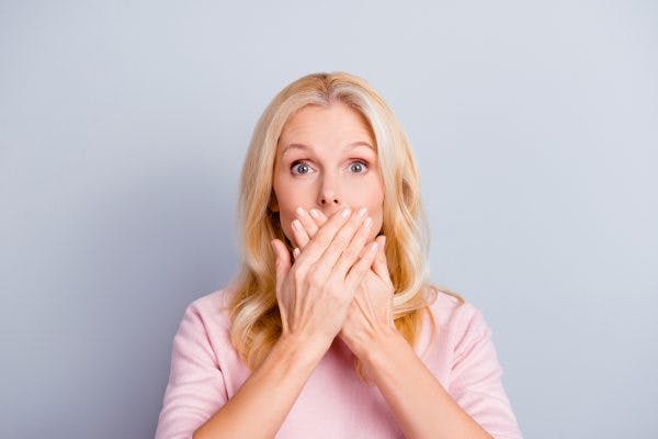 woman covering her mouth to symbolize that she cannot speak because she has aphasia after TBI