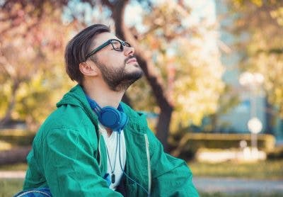 homme assis sur un banc dans un parc prenant des respirations profondes pour soulager les vomissements après une blessure à la tête