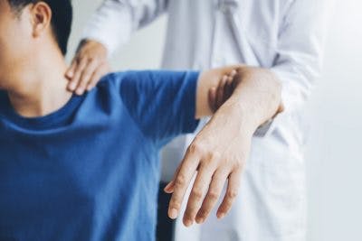 physical therapist adjusting arm mobility for massive stroke recovery