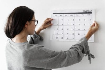 woman hanging up a calendar to improve her brain injury organization skills