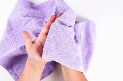 person holding a soft towel to stimulate the brain with sensory reeducation exercises