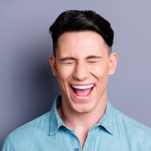 man closing eyes and smiling because he has disinhibition after brain injury