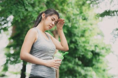 woman runner closing eyes and resting because she has heat sensitivity after TBI