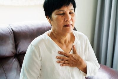 woman putting hand on chest and breathing hard because she has autonomic dysfunction