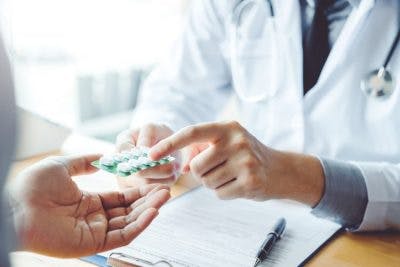 doctor handing packet of gabapentin to patient with brain damage