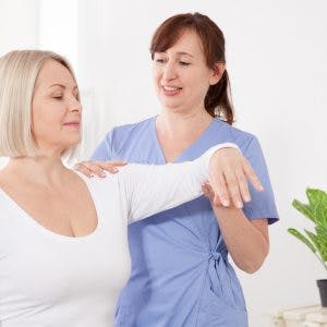 physiotherapist helping a stroke patient to use compensatory strategies safely