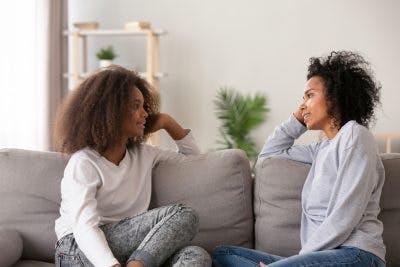 mother sitting on couch with daughter talking about lack of empathy after brain injury