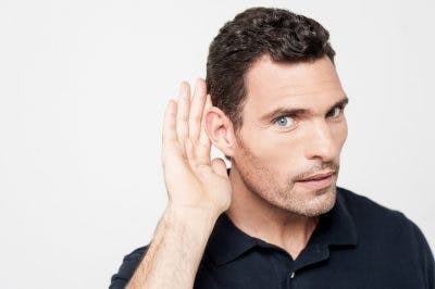 El hombre pone la mano detrás de la oreja porque no puede oír't hear