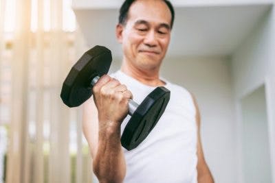 man lifting weights with arm to treat contractures after brain injury