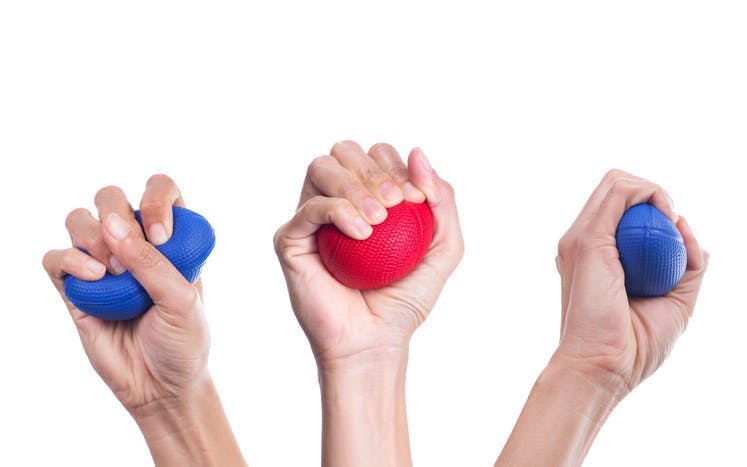 three hands squeezing therapy balls for strengthening exercises