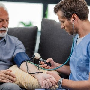 Doctor manually measuring blood pressure of patient who may have high blood pressure after head injury