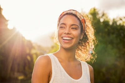 smiling woman in sunshine feeling happy 