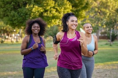 Three women jogging together in park to stay fit