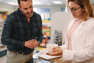 pharmacist showing customer how to use medication