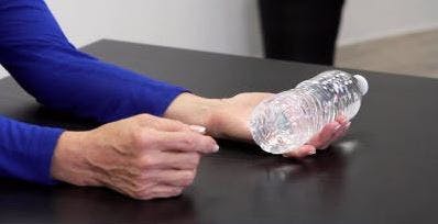 therapist holding water bottle in hand for exercise