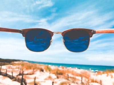 point of view shot of person holding sunglasses in front of their face