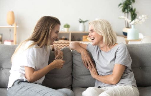 two women sitting on sofa talking