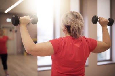 woman doing shoulder press in gym