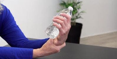 therapist holding water bottle in hand like a dumbbell