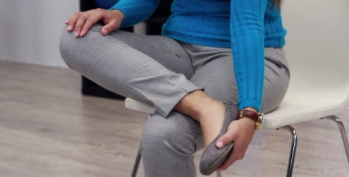 terapeuta com o pé em movimento durante o exercício de queda do pé