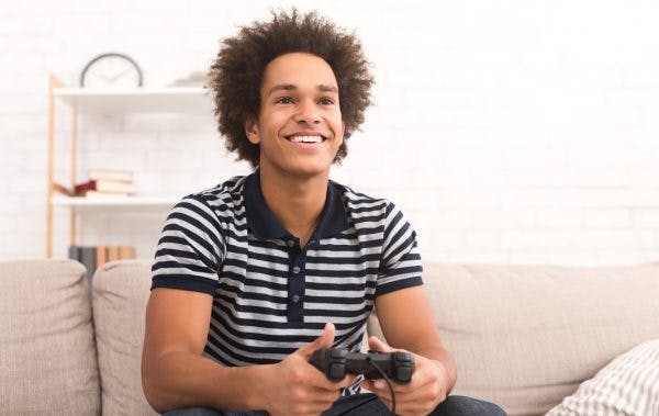 Young man smiling playing video games for TBI recovery